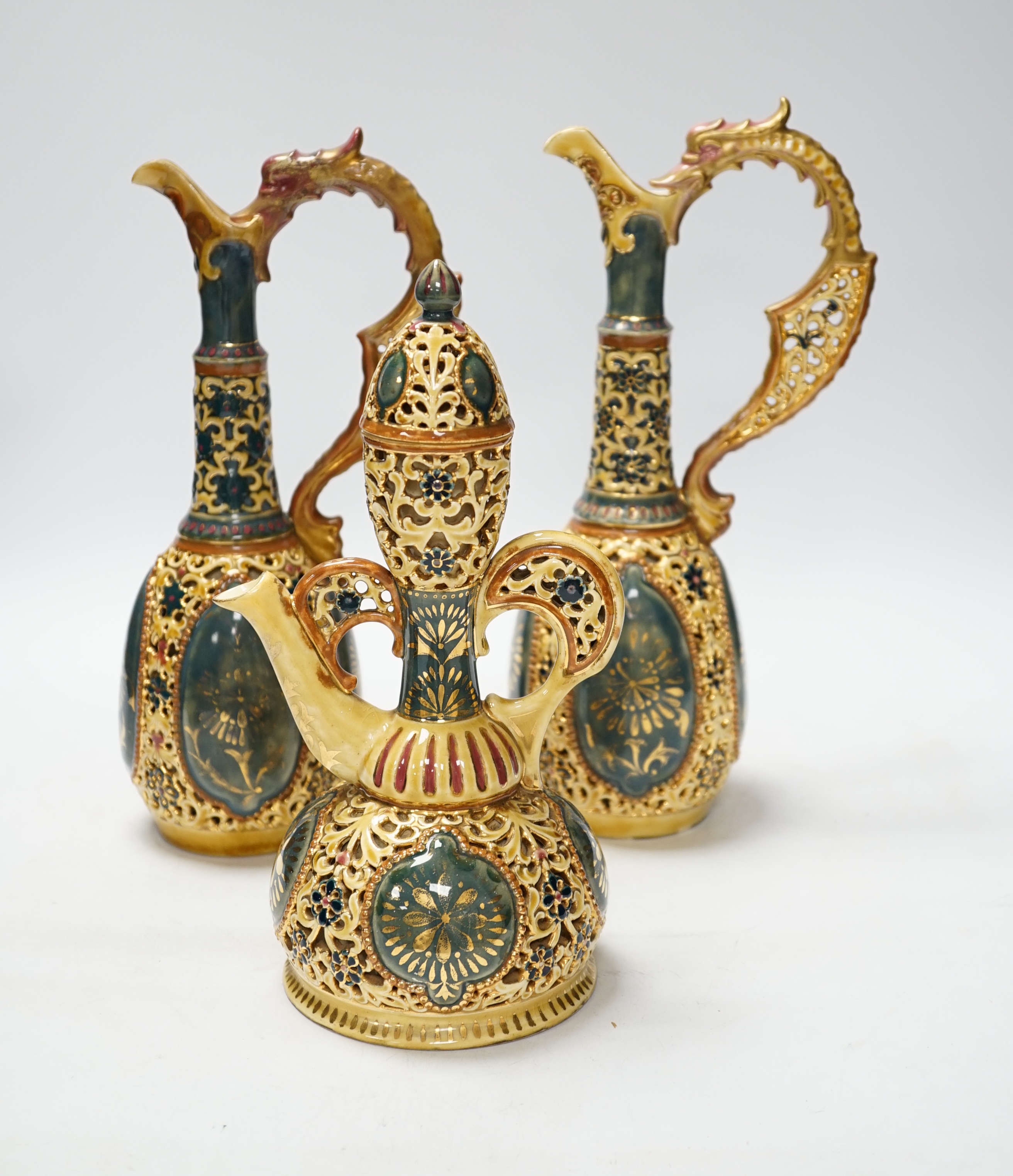 A pair of Zsolnay ewers and a similar ewer with cover, tallest 30cm high
